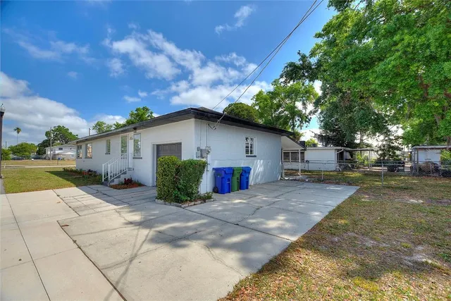 a view of a house with backyard and a tree