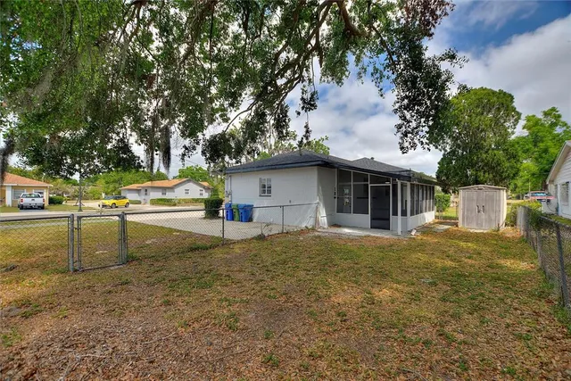a view of a house with backyard and trees