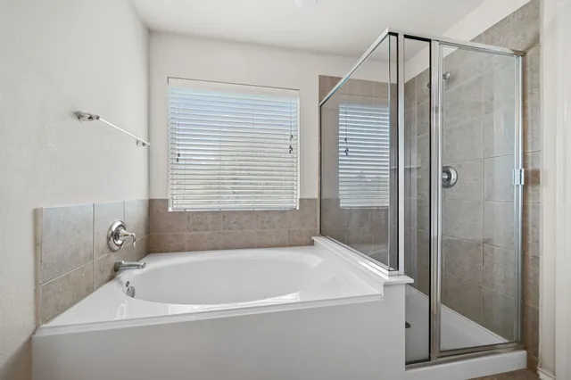 a white bath tub sitting next to a shower