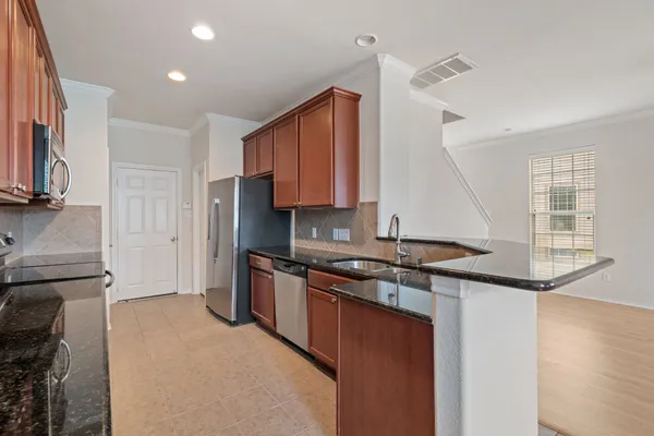 a kitchen with stainless steel appliances granite countertop a sink stove and refrigerator
