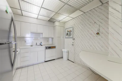 a kitchen with white cabinets and white appliances