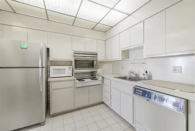a kitchen with a sink a refrigerator and cabinets