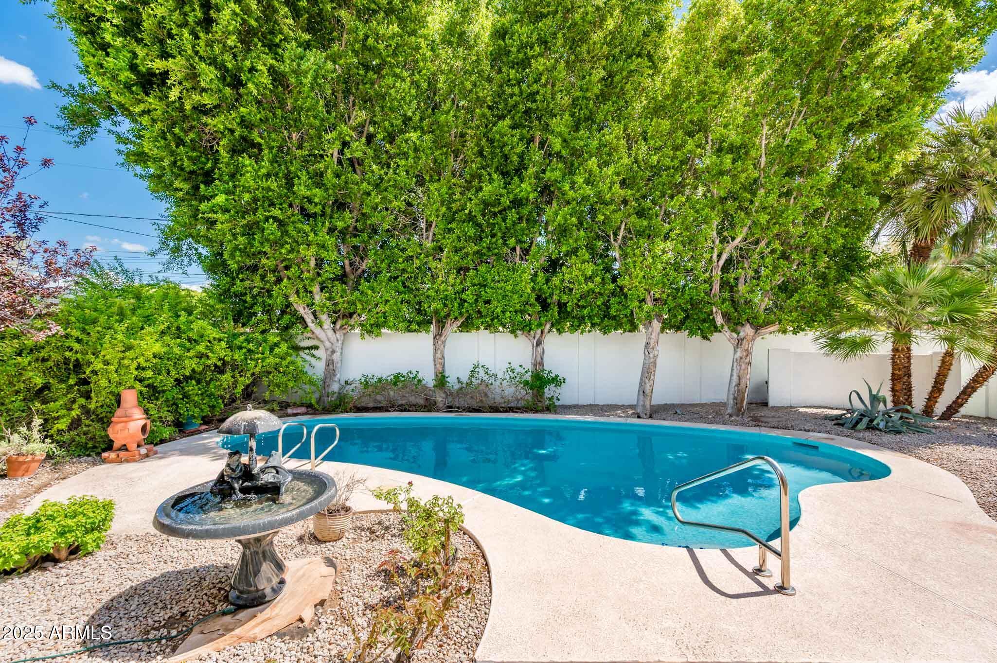 1224 East Rancho Drive Phoenix, AZ 85014 - Photo 35 of 38 a view of a backyard with table and chairs plants and trees