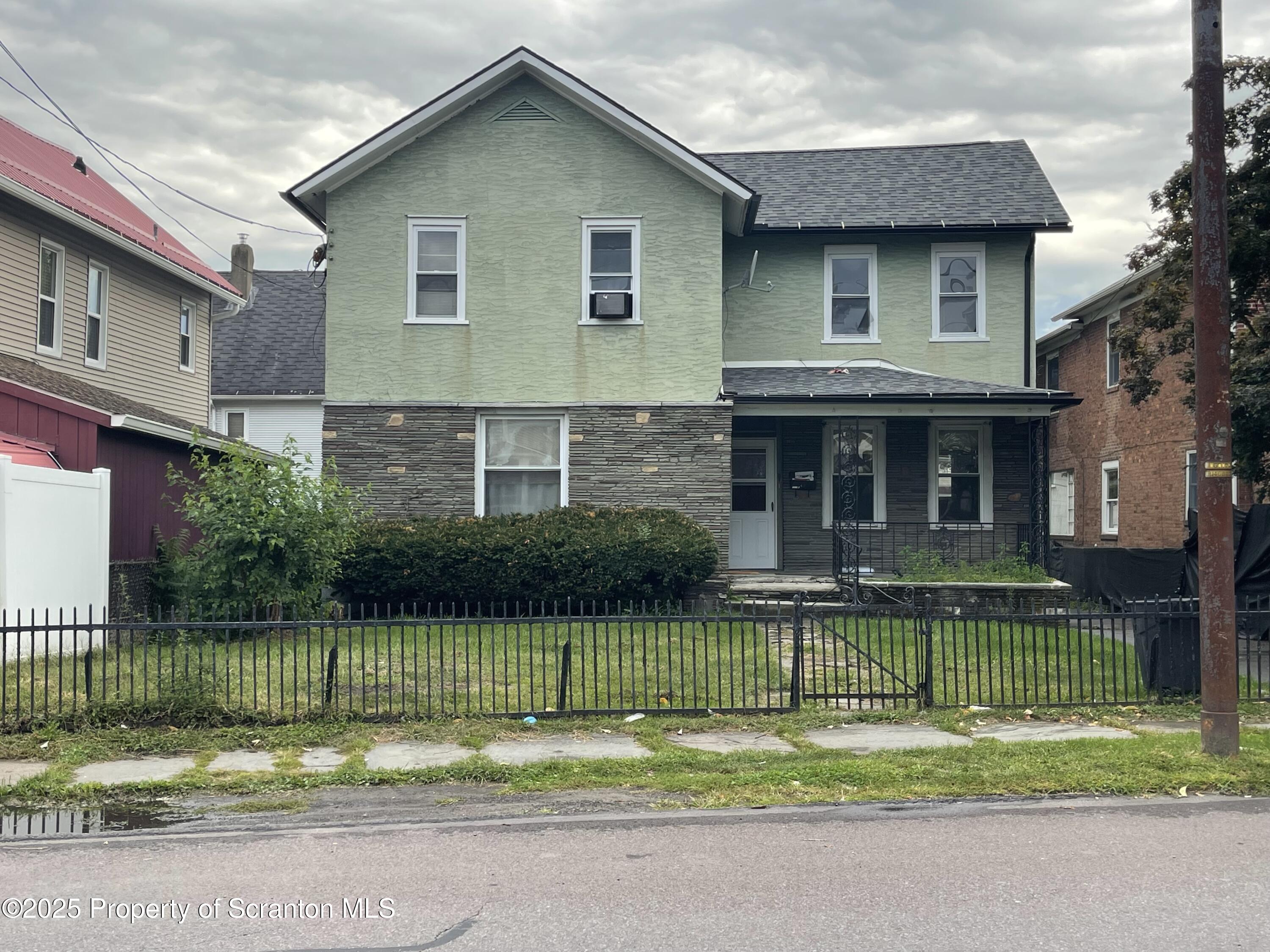 a front view of a house with a garden and outdoor seating