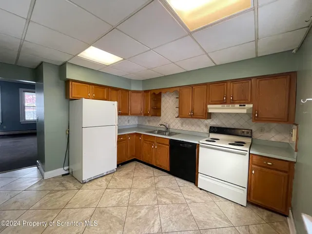 a kitchen with stainless steel appliances granite countertop a stove a sink dishwasher and a refrigerator