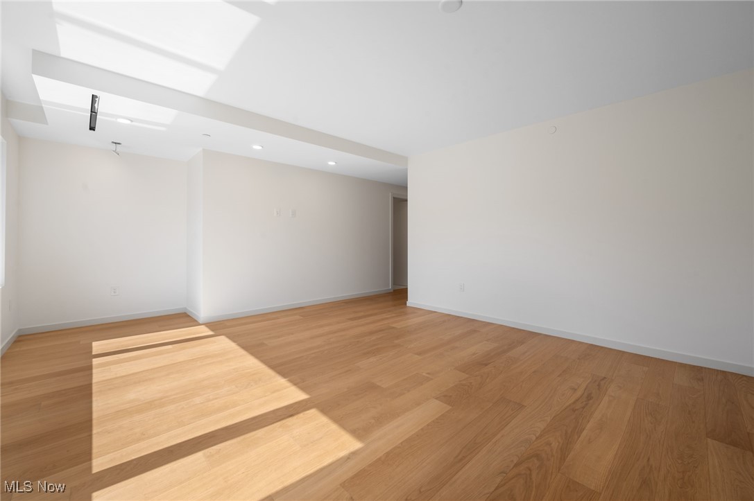 22700 Lake Road, Unit 306 Rocky River, OH 44116 - Photo 14 of 28 Empty room with light wood-style floors, recessed lighting, and a skylight