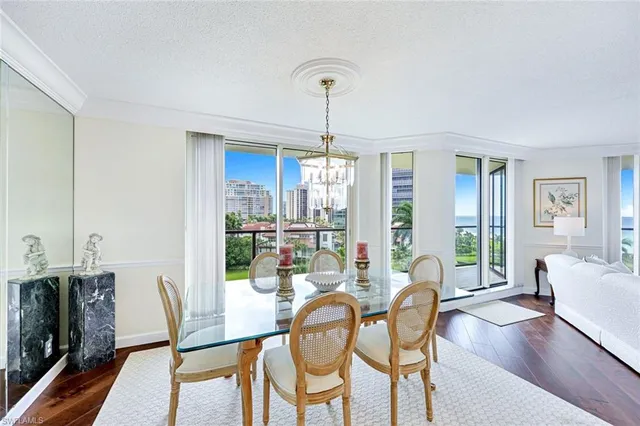 a dining room with furniture a chandelier and wooden floor