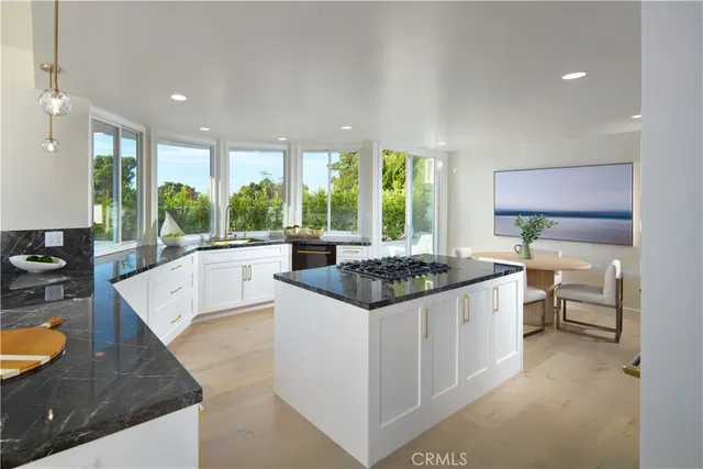 a large white kitchen with stainless steel appliances granite countertop a stove a sink and a granite counter tops