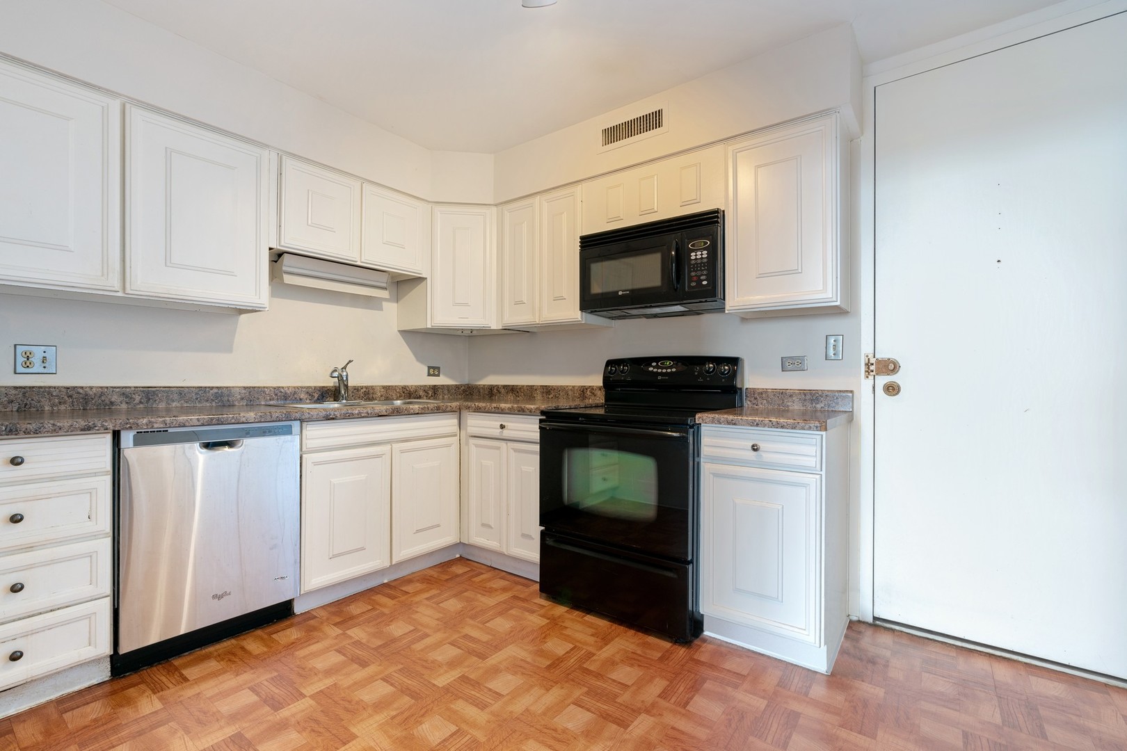 6007 North Sheridan Road, Unit 39C Chicago, IL 60660 - Photo 9 of 19 a kitchen with granite countertop white cabinets and stainless steel appliances