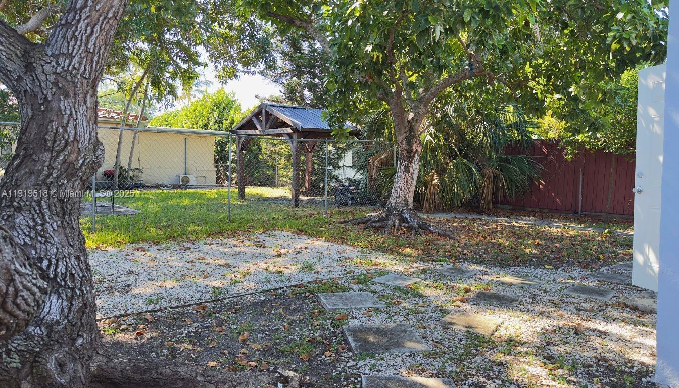 720 82nd Street, Unit 718 Miami Beach, FL 33141 - Photo 11 of 12 a view of a backyard with a tree and a small cabin