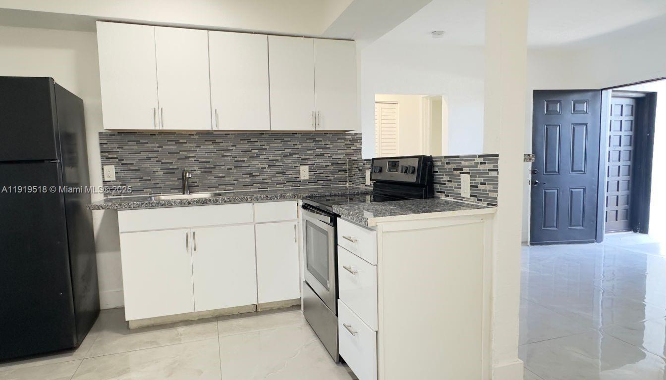 720 82nd Street, Unit 718 Miami Beach, FL 33141 - Photo 3 of 12 a kitchen with granite countertop white cabinets and stainless steel appliances