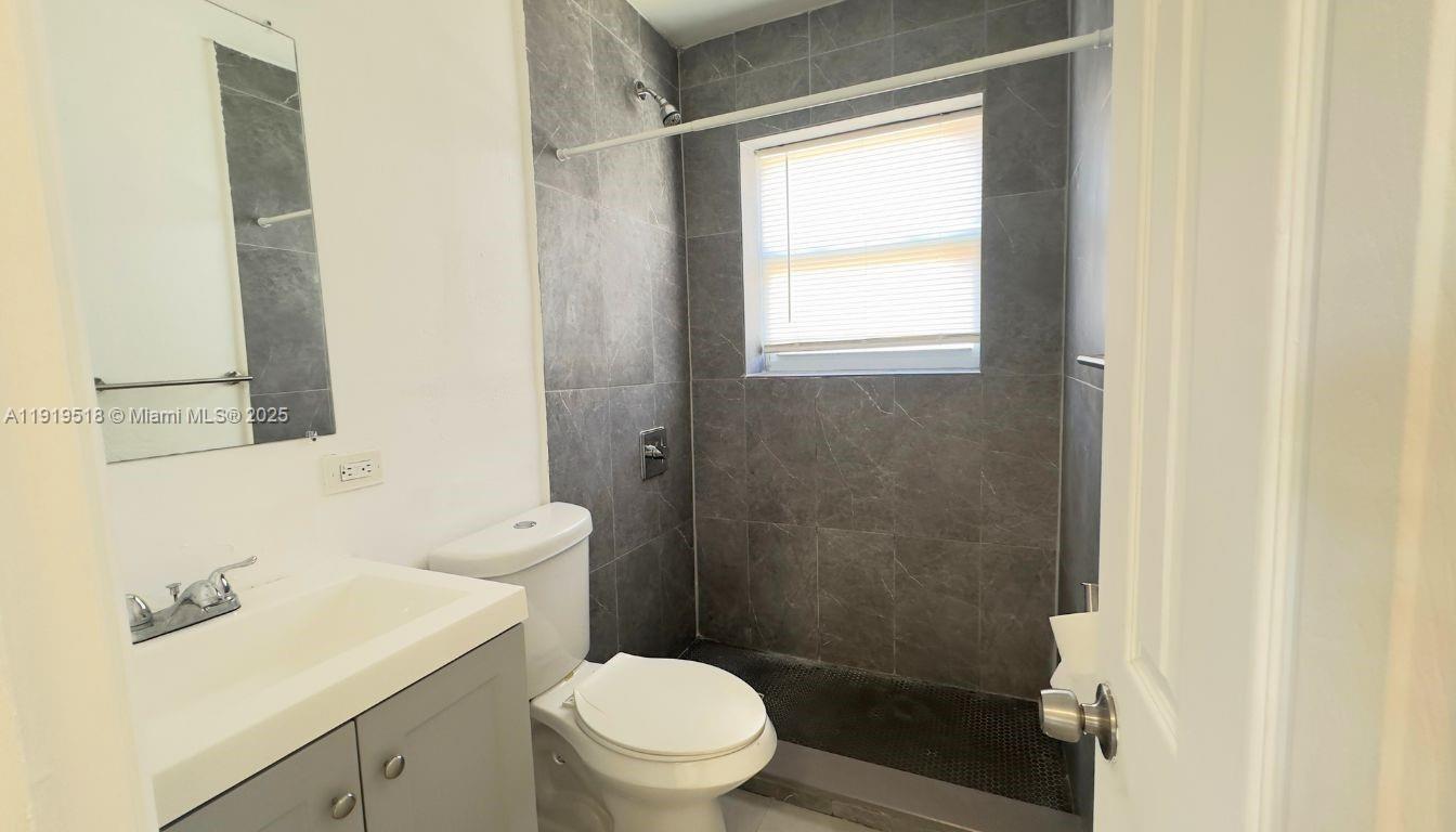 720 82nd Street, Unit 718 Miami Beach, FL 33141 - Photo 6 of 12 a bathroom with a sink a toilet and shower
