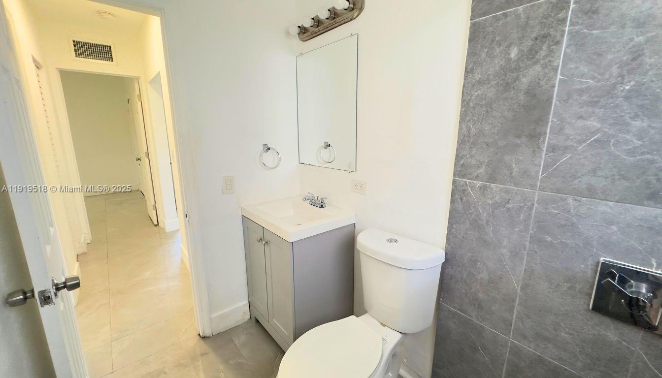 720 82nd Street, Unit 718 Miami Beach, FL 33141 - Photo 7 of 12 a white toilet sitting next to a bathroom sink