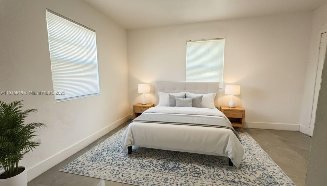 720 82nd Street, Unit 718 Miami Beach, FL 33141 - Photo 8 of 12 a bedroom with a bed lamp and a potted plant