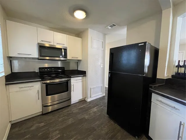 a kitchen with a refrigerator and a stove top oven