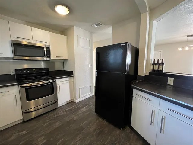 a kitchen with stainless steel appliances and white cabinets