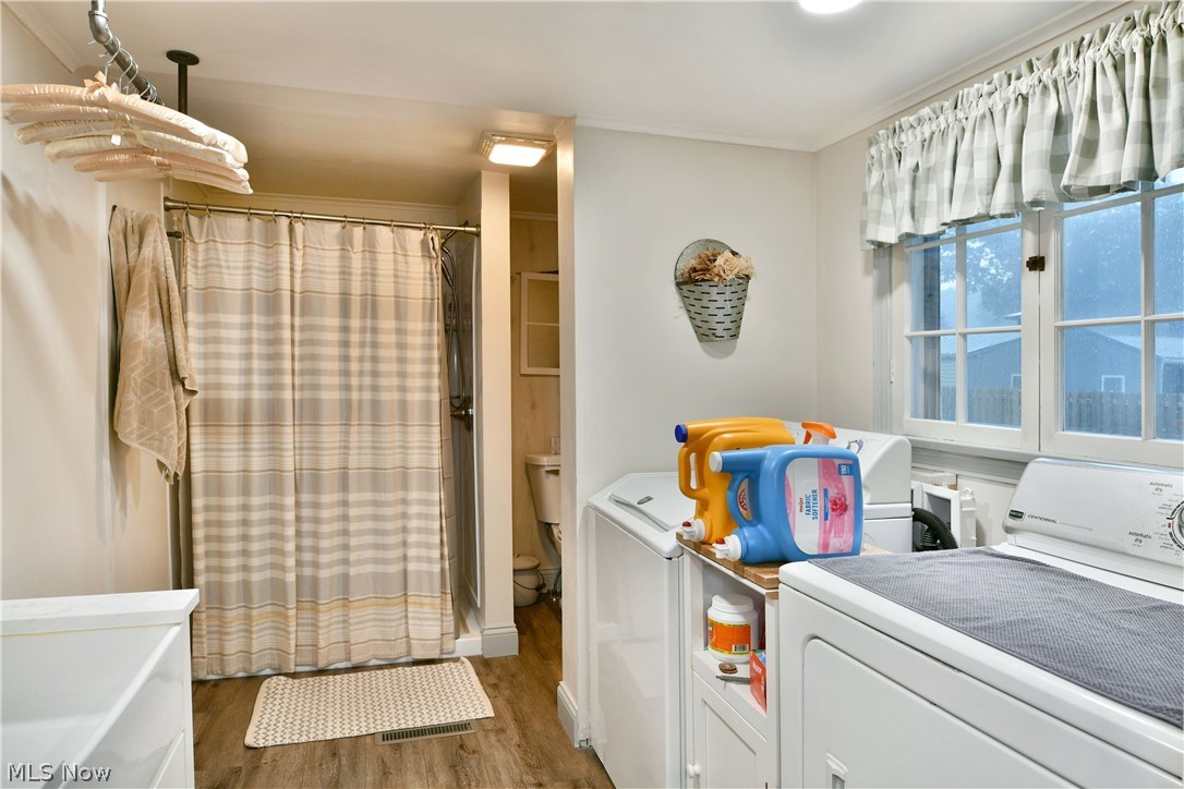8683 King Graves Road Northeast Warren, OH 44484 - Photo 27 of 50 Laundry area featuring wood-finish flooring, a double window, and a built-in folding counter