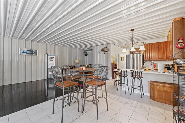 a kitchen with stainless steel appliances granite countertop a kitchen island a table and chairs
