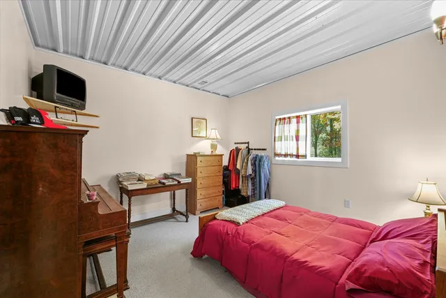 a bedroom with a bed and a dresser with wooden floor