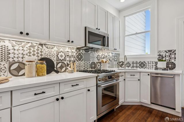 a kitchen with white cabinets stainless steel appliances and sink