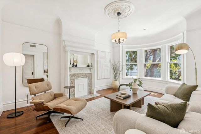 a living room with furniture chandelier and a large window