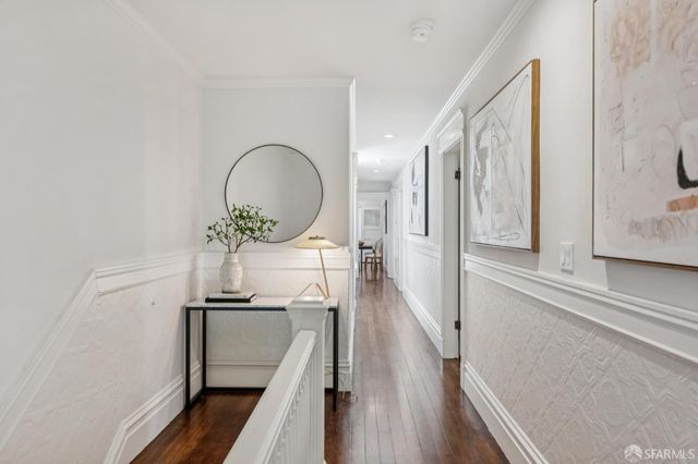 a view of a hallway with wooden floor and staircase