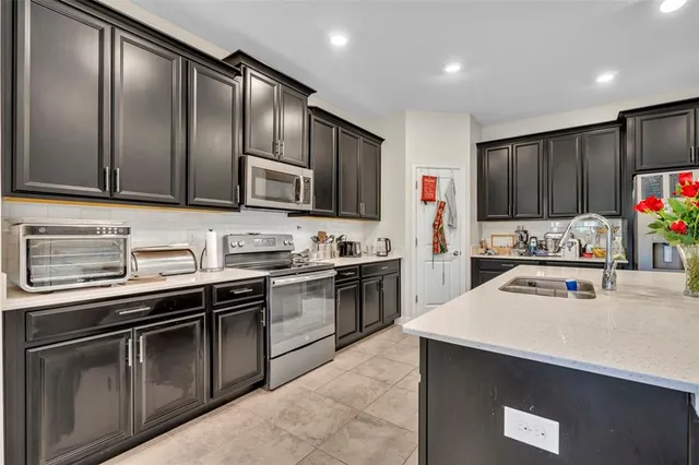 a kitchen with stainless steel appliances granite countertop a sink stove and refrigerator