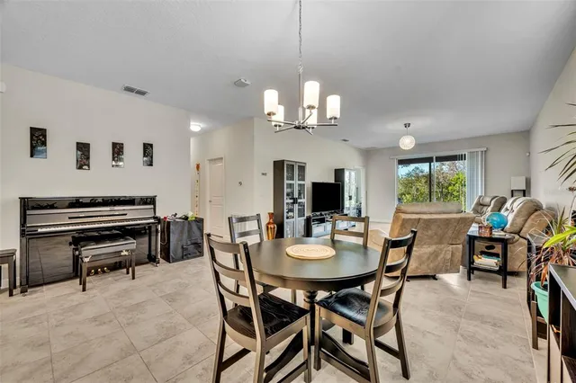 a view of a dining room with furniture a chandelier and a window