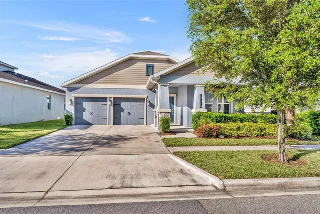 a front view of a house with a garden and plants