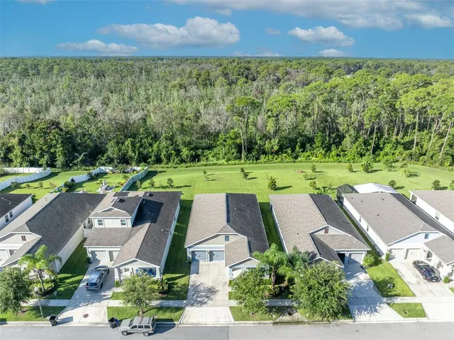 an aerial view of residential houses with outdoor space and street view