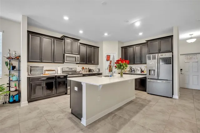 a kitchen with refrigerator a microwave a sink and cabinets