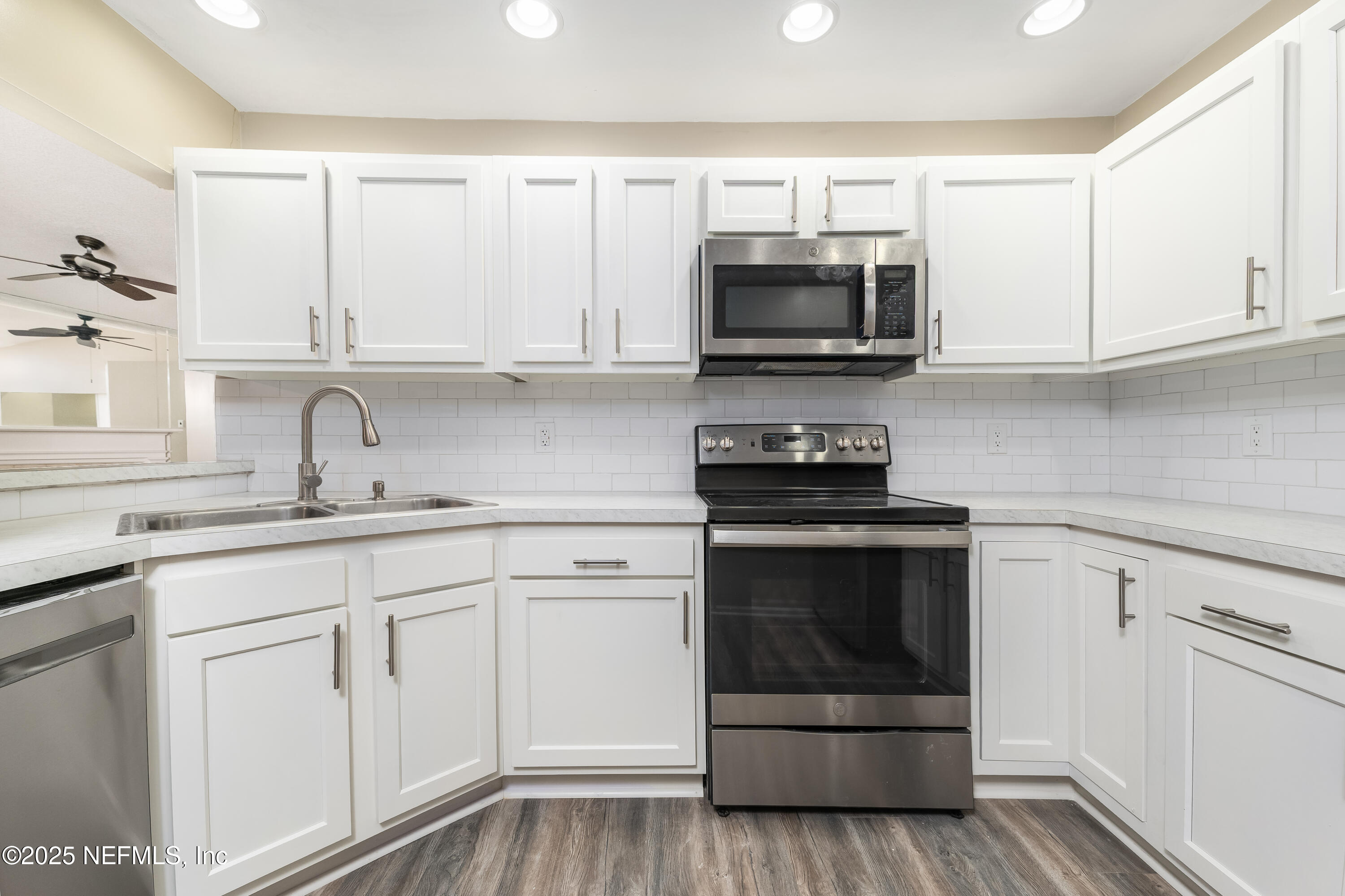 85 Debarry Avenue, Unit 3021 Orange Park, FL 32073 - Photo 14 of 35 a kitchen with white cabinets and stainless steel appliances