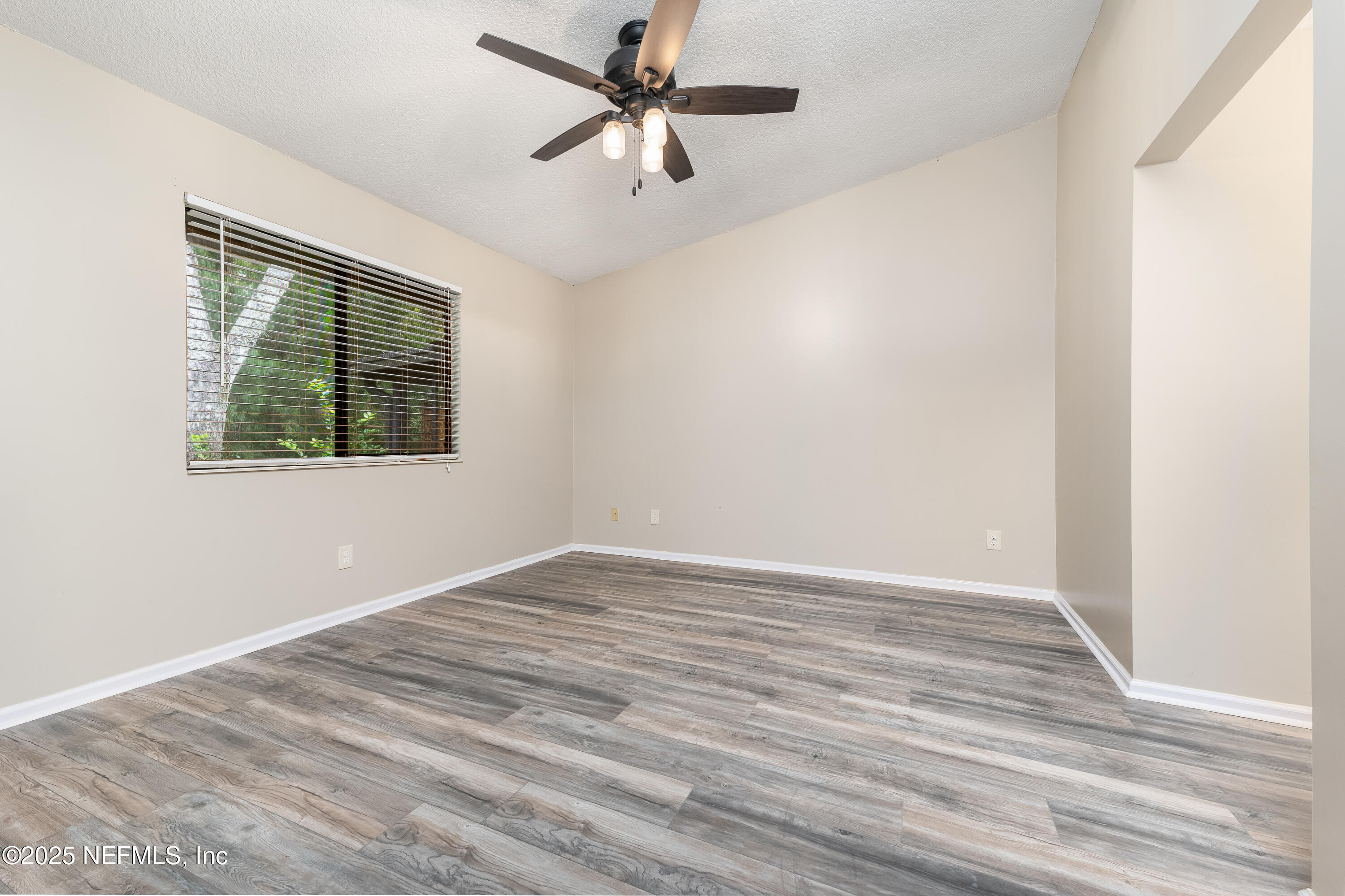 85 Debarry Avenue, Unit 3021 Orange Park, FL 32073 - Photo 19 of 35 a view of an empty room with wooden floor and a window