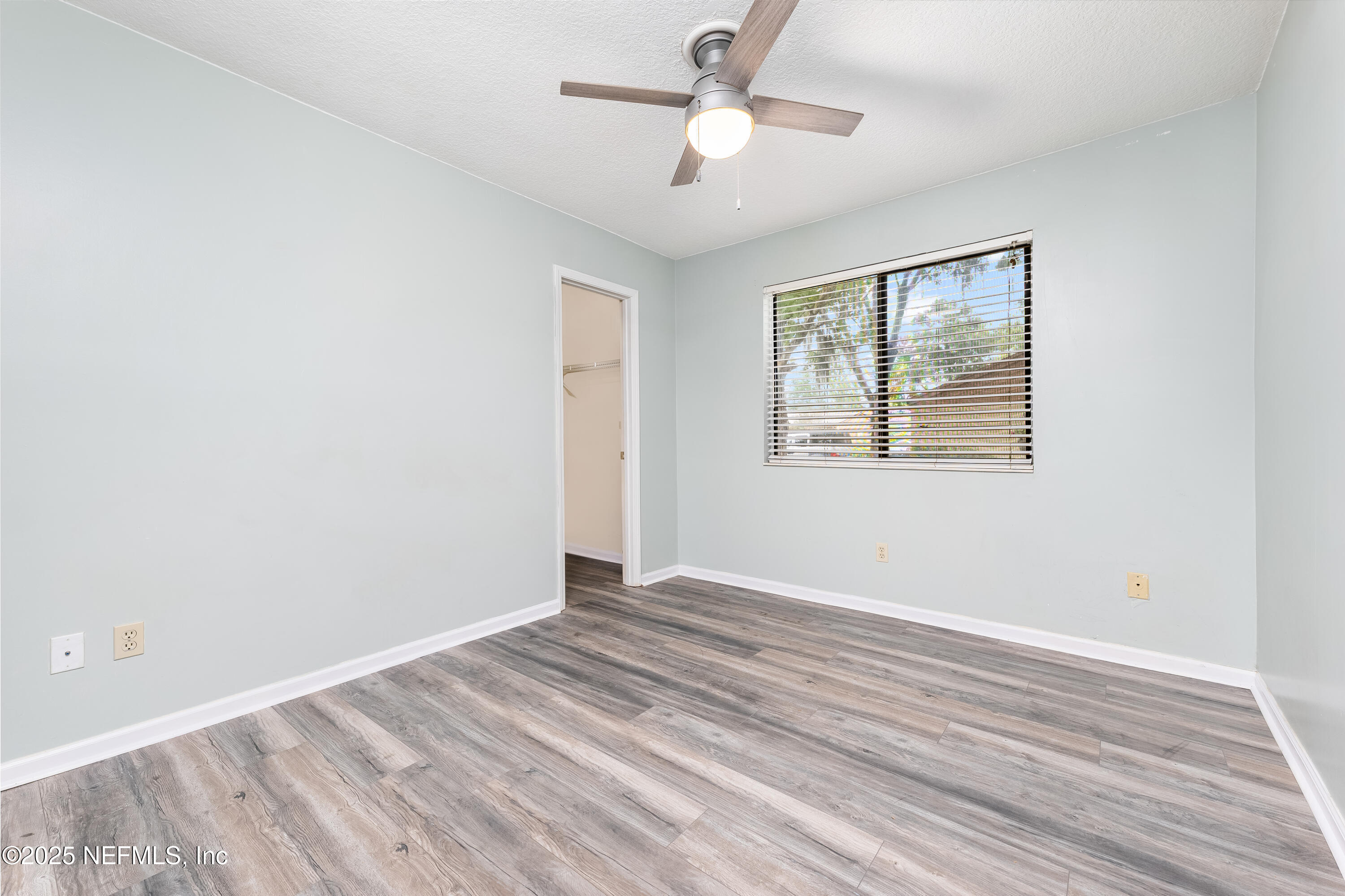 85 Debarry Avenue, Unit 3021 Orange Park, FL 32073 - Photo 24 of 35 a view of an empty room with wooden floor and a window