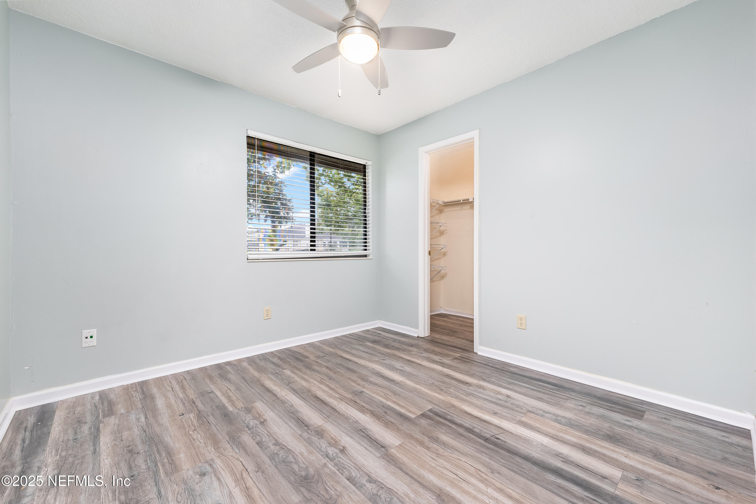 85 Debarry Avenue, Unit 3021 Orange Park, FL 32073 - Photo 26 of 35 an empty room with wooden floor chandelier fan and windows