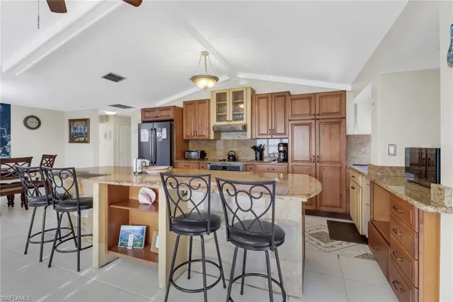 a kitchen with stainless steel appliances a table and chairs in it