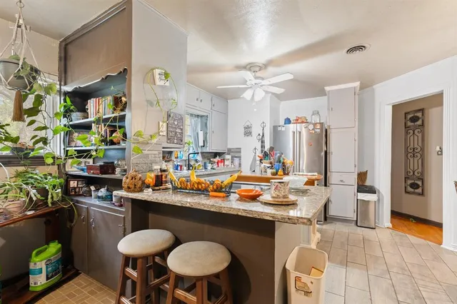 a kitchen with stainless steel appliances a sink and a living room view