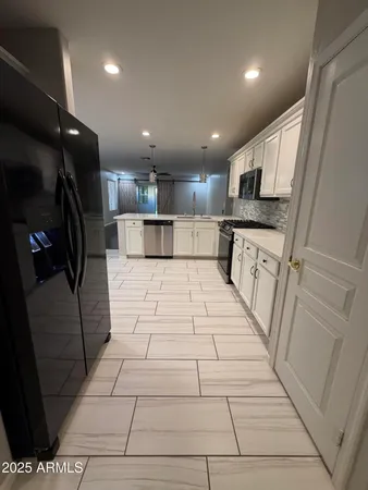 an empty room with wooden floor and windows with curtains