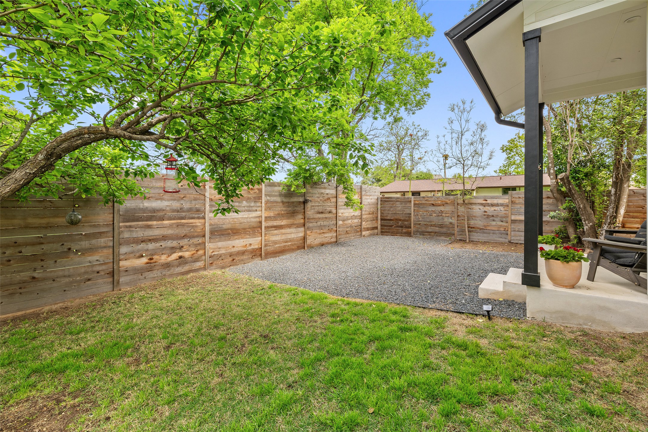 1504 Ruth Avenue, Unit 3 Austin, TX 78757 - Photo 38 of 39 A private backyard oasis featuring a lush lawn, gravel patio, and sturdy wooden fencing.