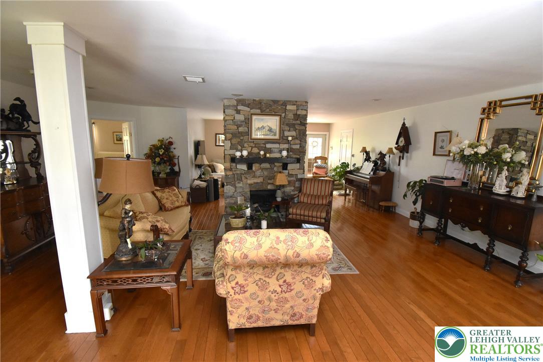 424 Grape Street Whitehall, PA 18052 - Photo 29 of 56 This expansive living area features warm wood floors and a prominent stone fireplace, perfect for gatherings.