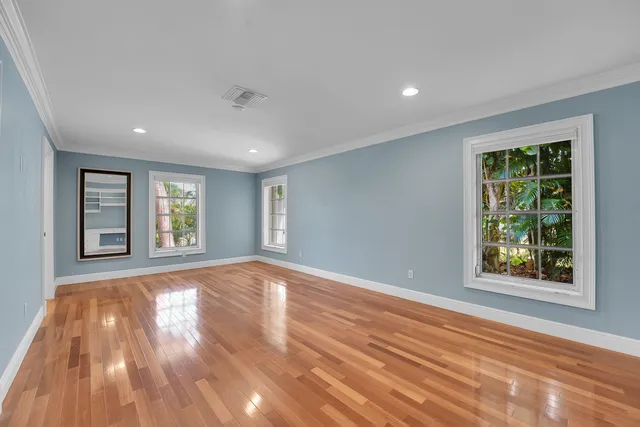 a view of an empty room with wooden floor closet and fire place
