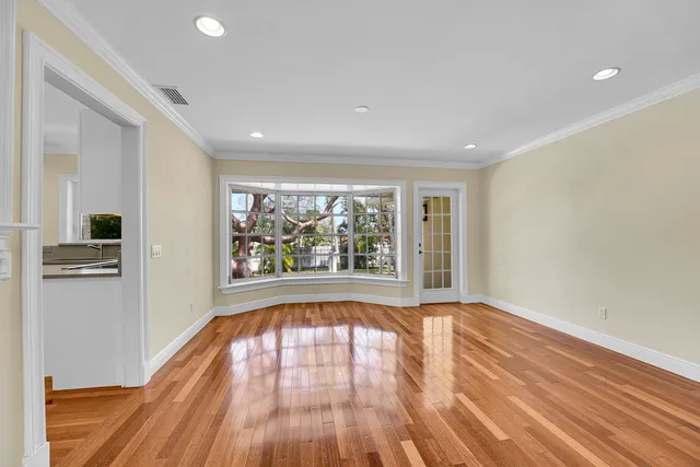 a view of an empty room window and wooden floor