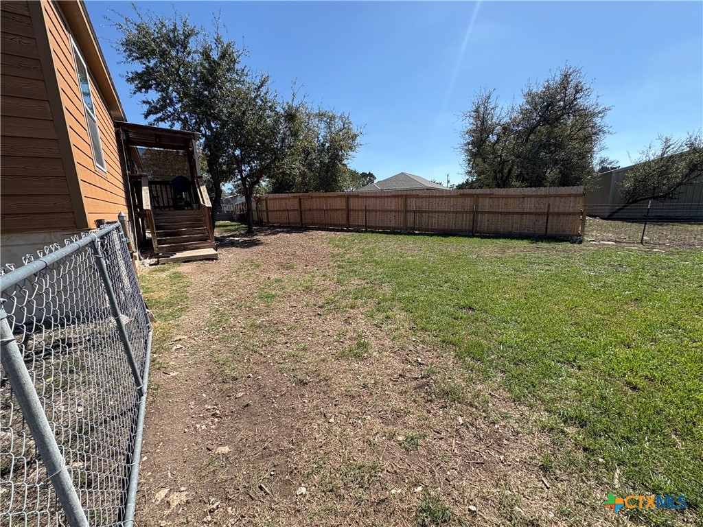 371 Moosehead Road Spring Branch, TX 78070 - Photo 6 of 17 a view of backyard with wooden fence and a trees