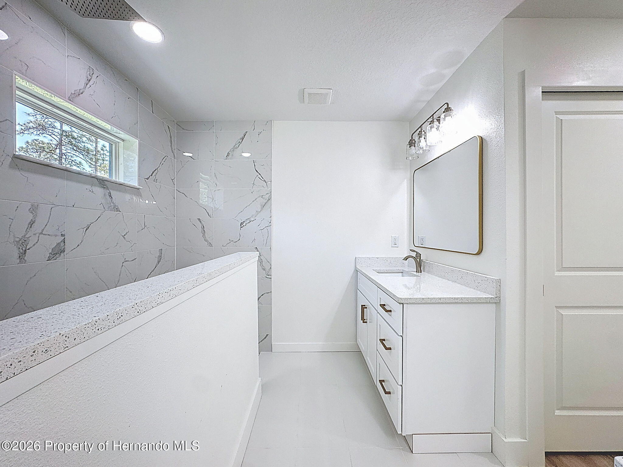 8988 Waterbird Way Weeki Wachee, FL 34613 - Photo 27 of 42 a spacious bathroom with a bathtub sink and mirror