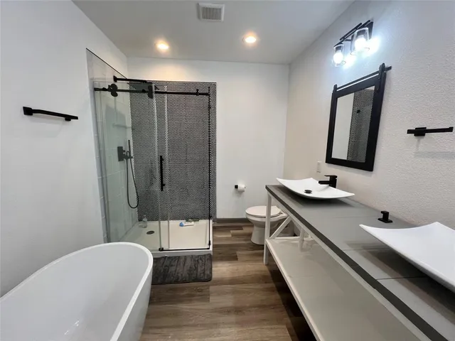 a bathroom with a double vanity sink toilet and shower