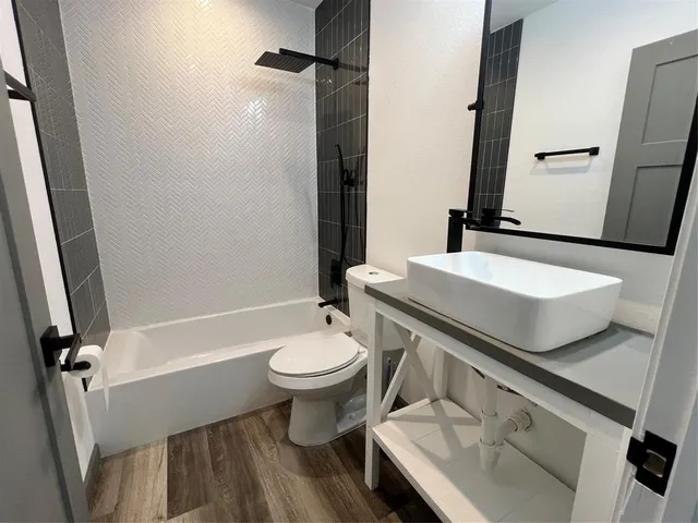 a bathroom with a sink a toilet a mirror and shower