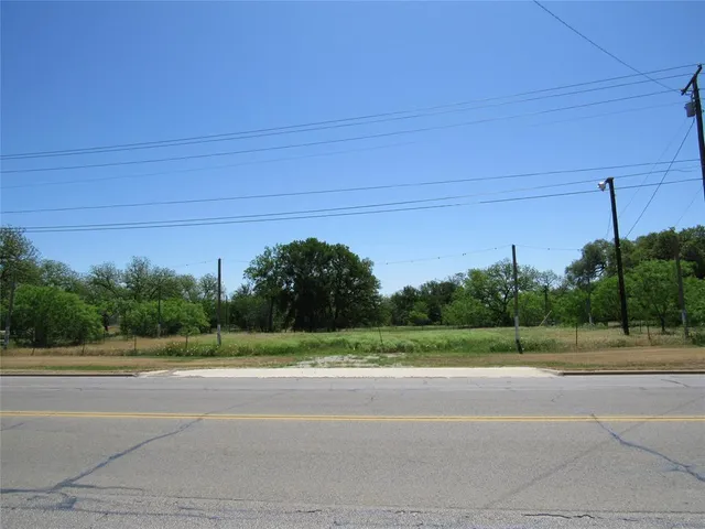 a view of a field with a tree in the background