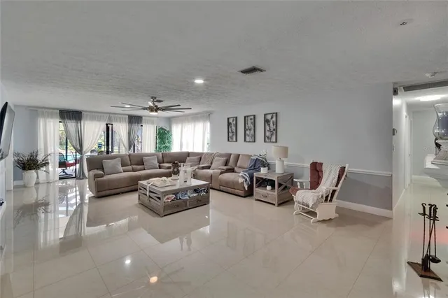 a living room with furniture a flat screen tv and kitchen view