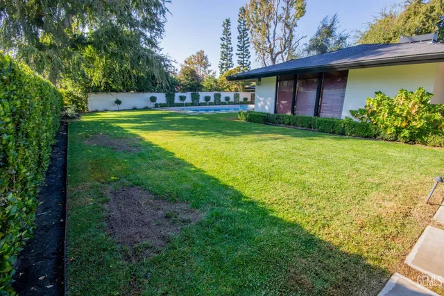 a view of a house with a yard and potted plants