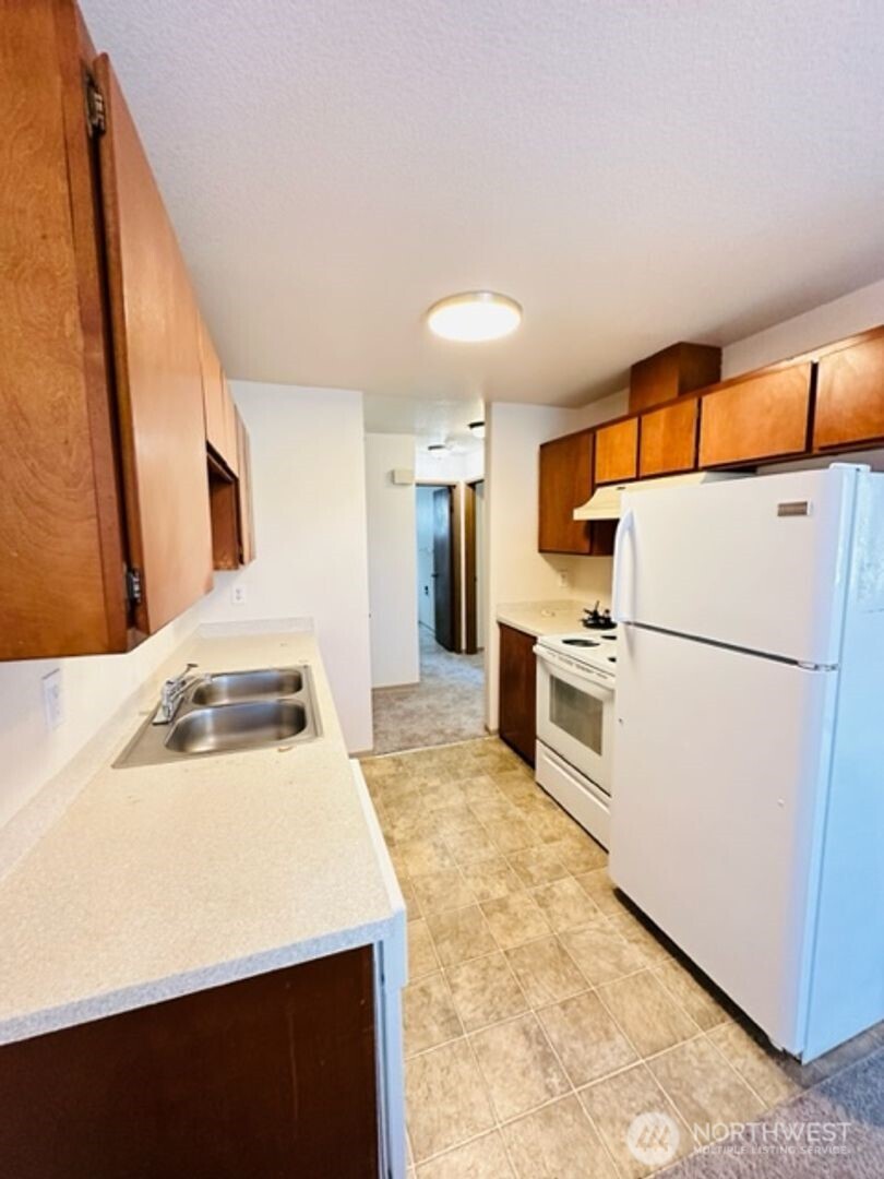 5631 Hwy Place, Unit 8 Everett, WA 98203 - Photo 6 of 11 a kitchen with white cabinets and white appliances